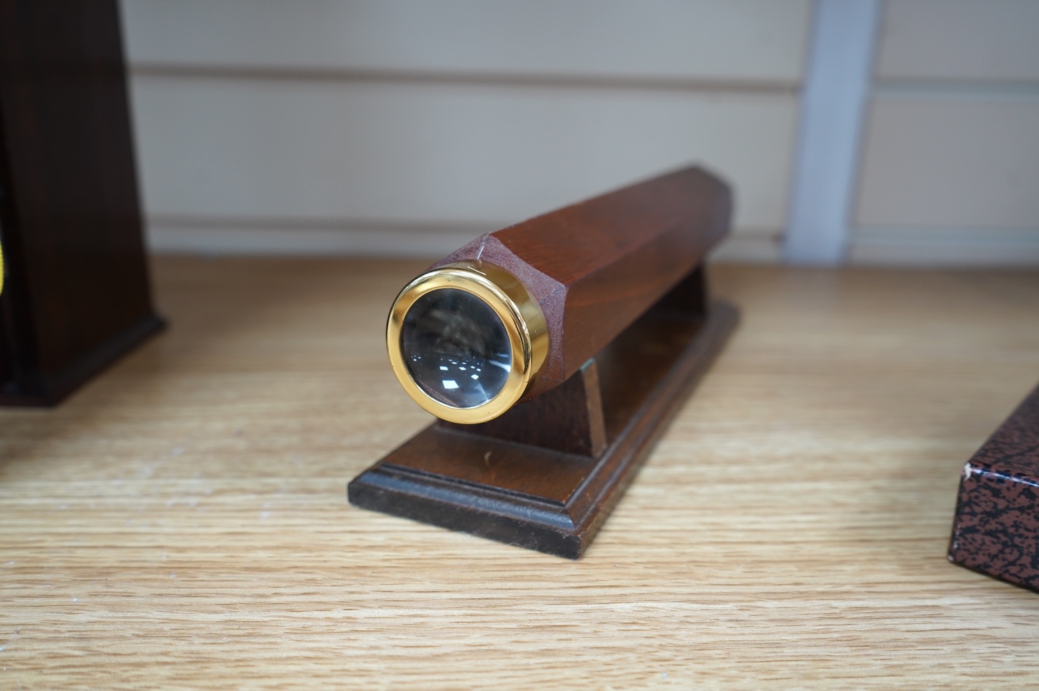 A reproduction 19th century style wooden bodied kaleidoscope on stand, 29.5cm, together with a wood cased brass solitaire set (one peg missing), 10.5cm diameter. Condition - fair.